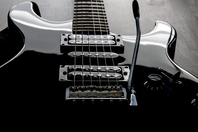 Close-up of a sleek black electric guitar with its glossy finish and intricate details of strings evoking inspiration and energy for guitar lessons.